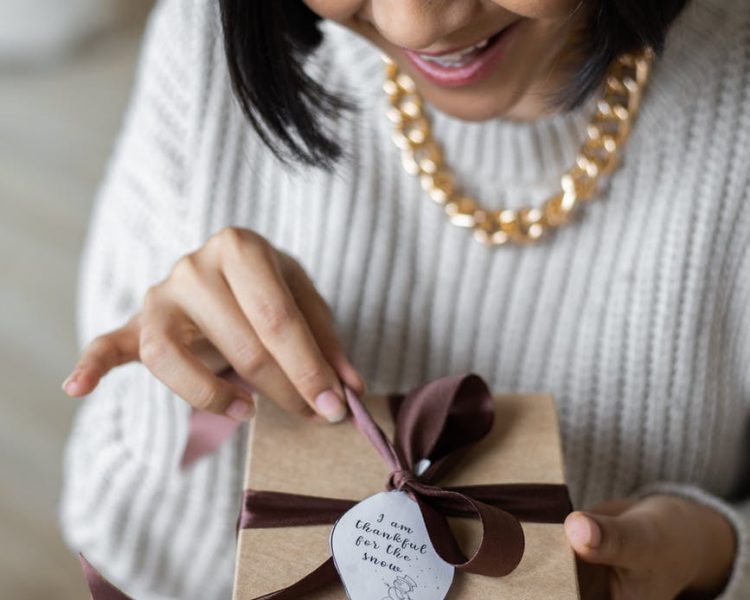 crop happy woman untying present box